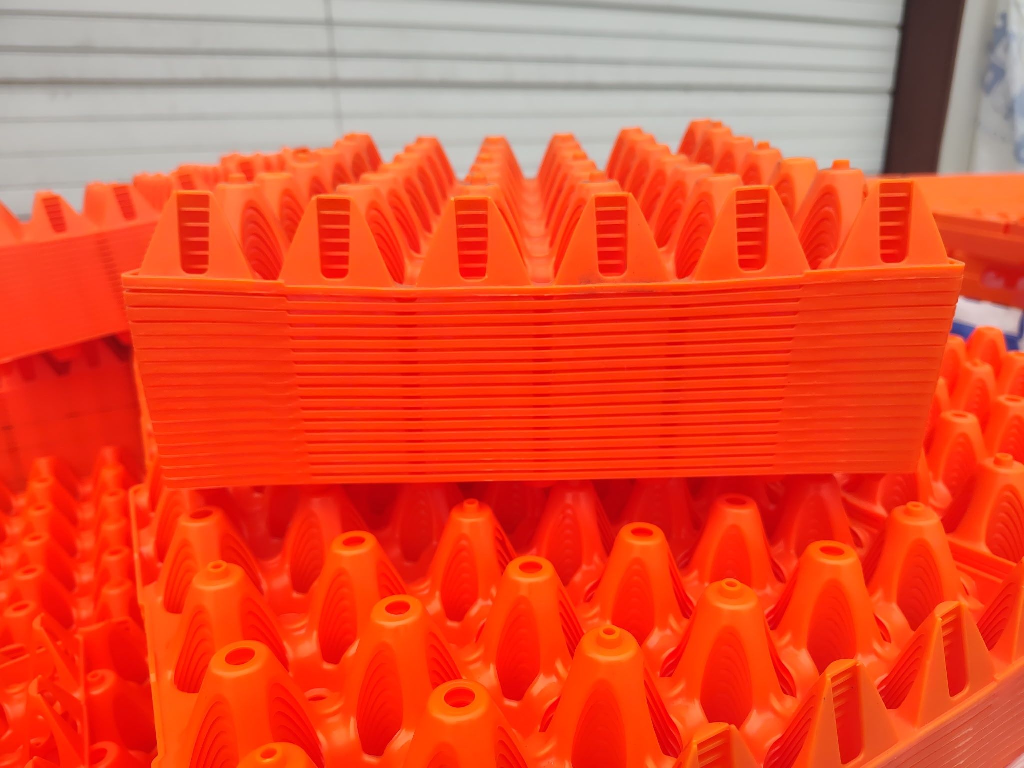 Close view of orange egg flats stacked showing the moulded egg cones