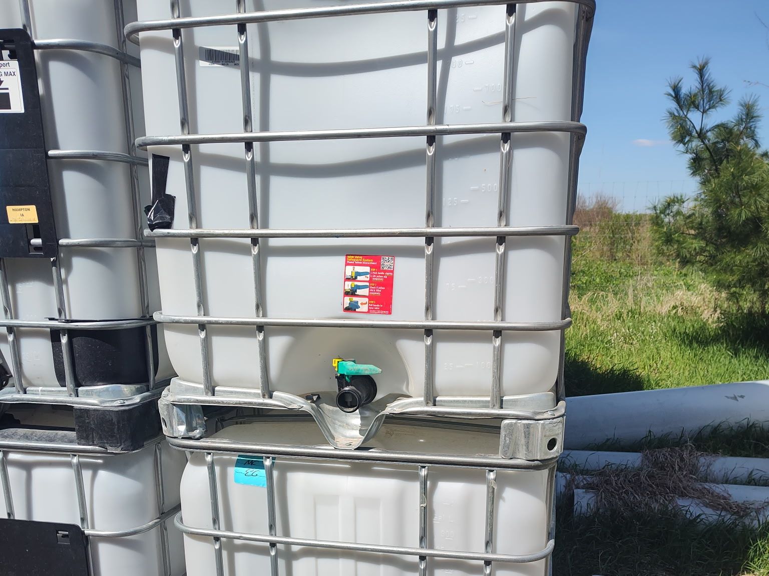IBC totes stacked two high with the fill cap and side label visible