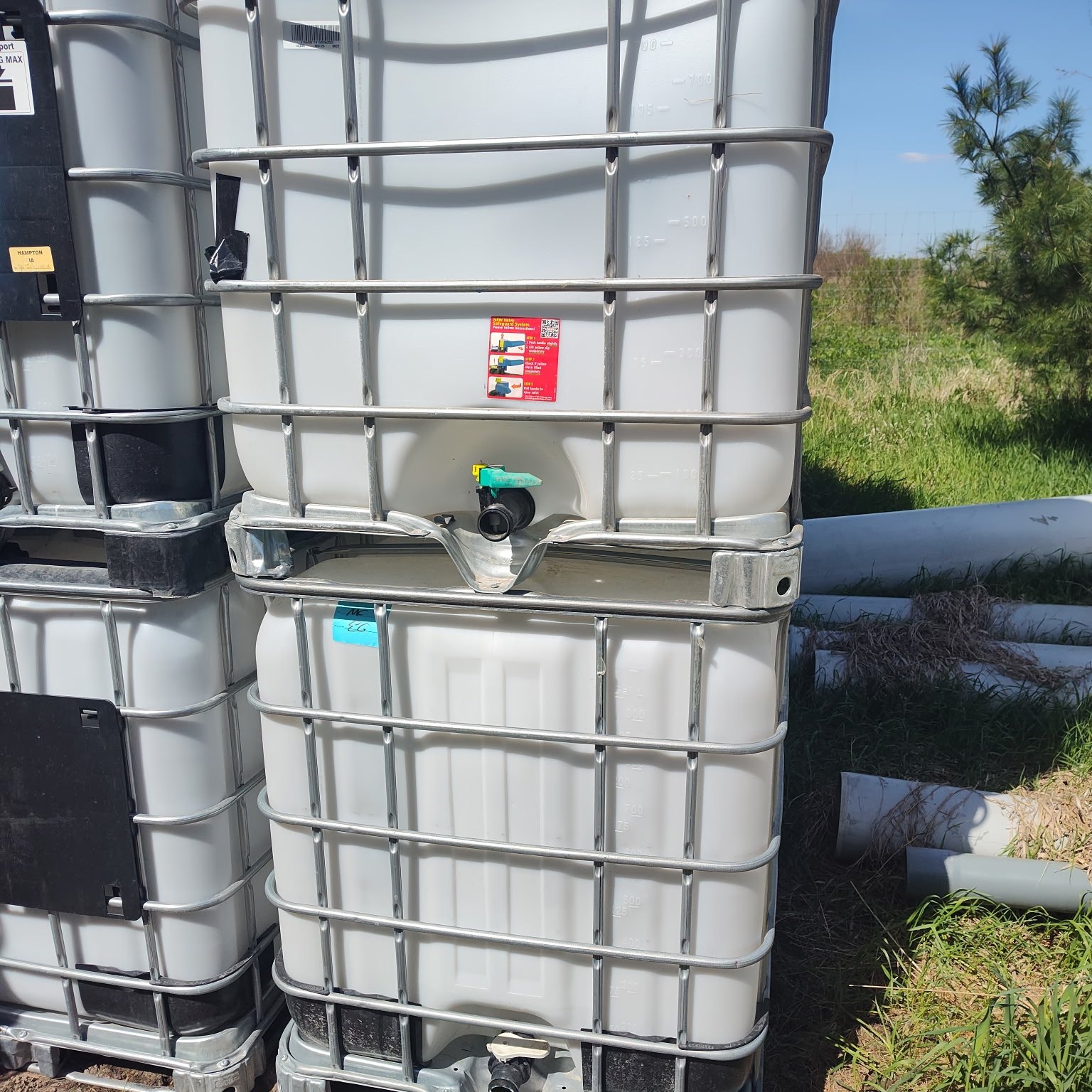 Stacked IBC totes two high with valves and fittings visible at the front